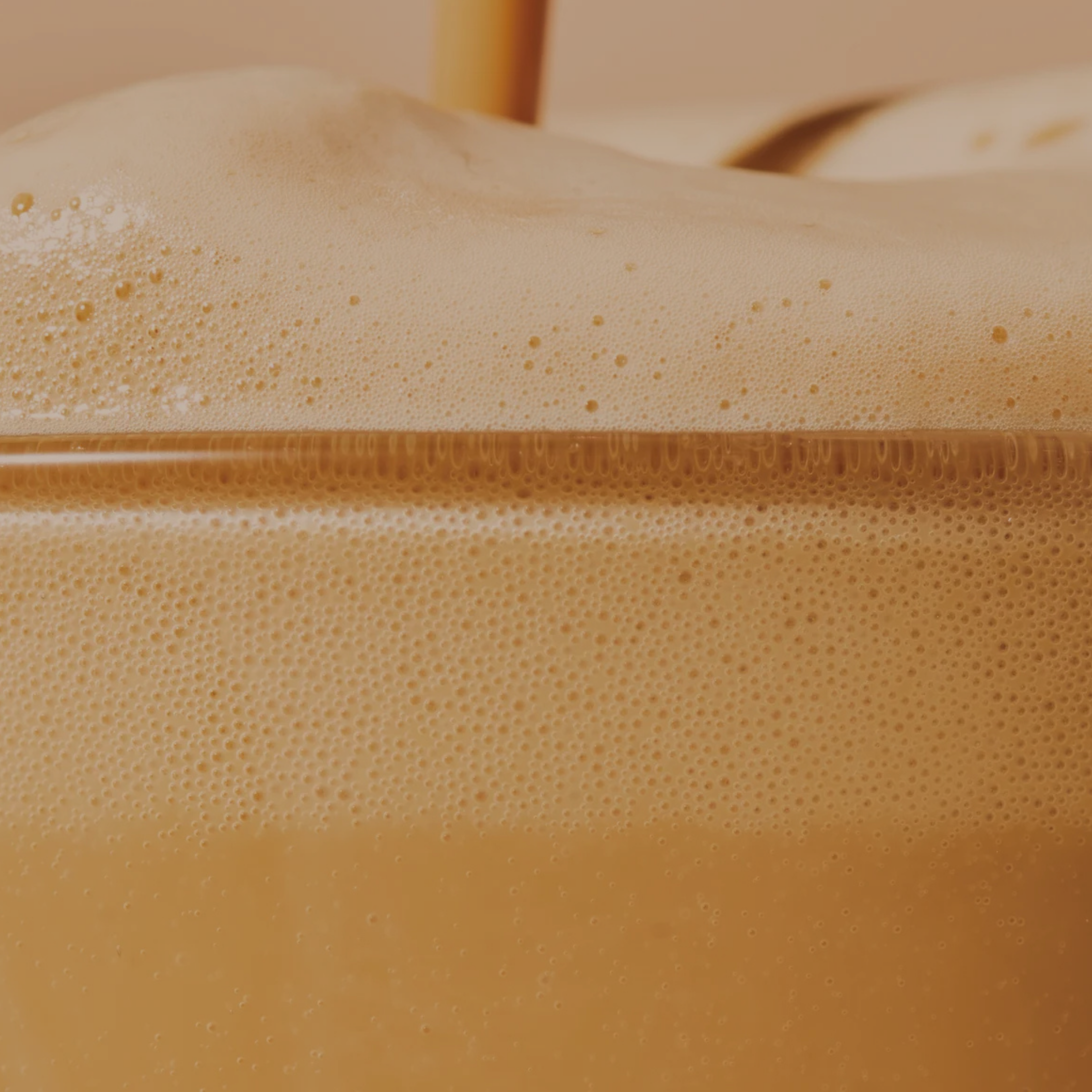 Close-up of a layered drink with a creamy top and a smooth bottom, possibly coffee or tea.